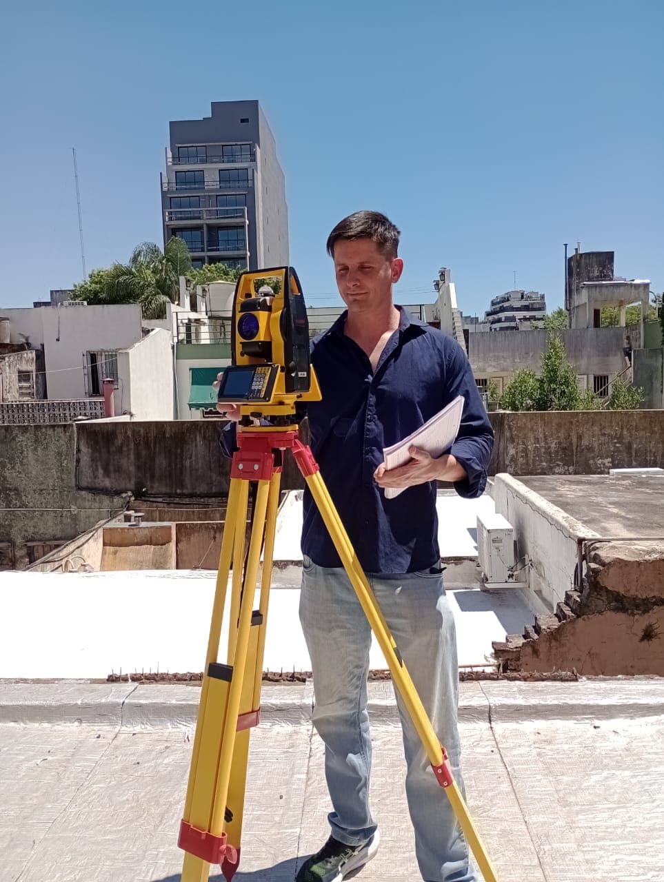 Pablo Venerus trabajando con estación total en una terraza de CABA