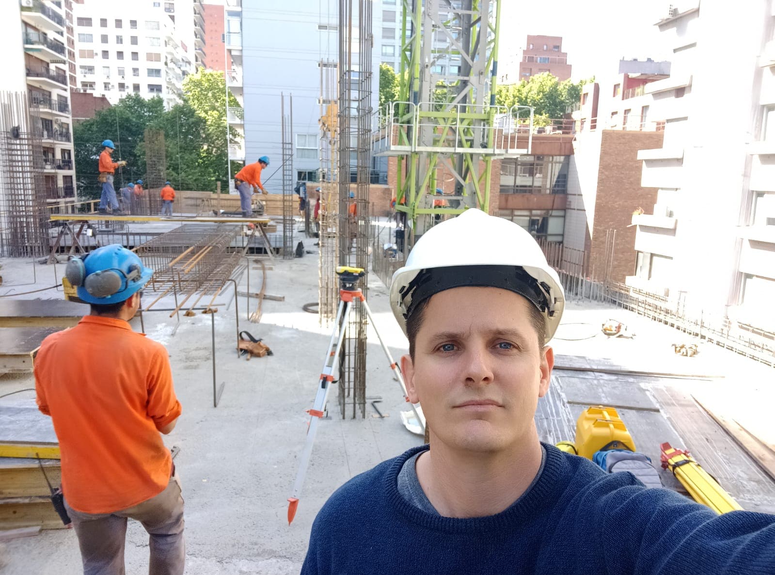 Pablo Venerus con casco en una obra activa junto a operarios trabajando