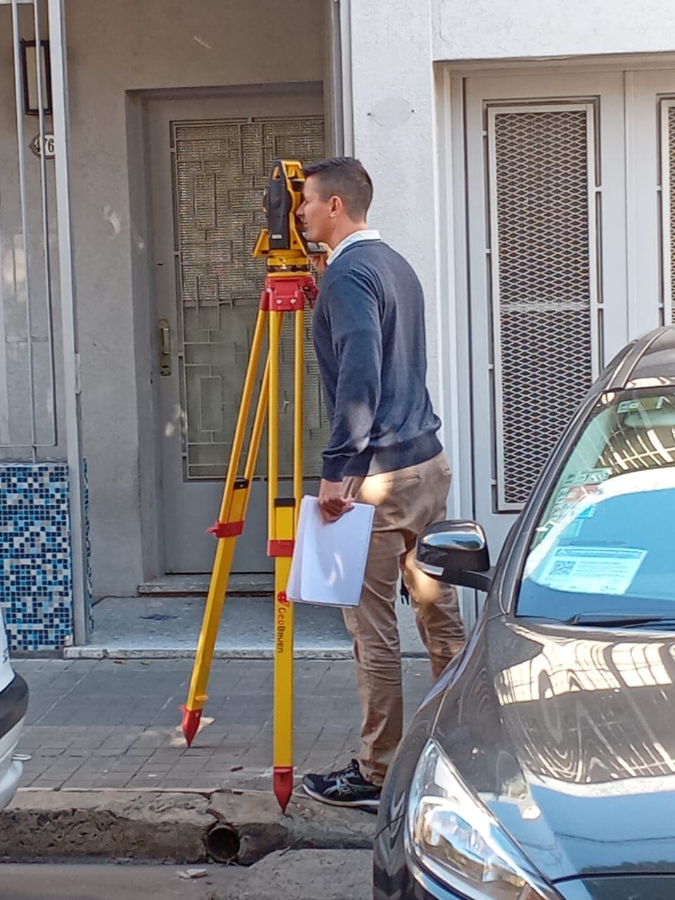Pablo Venerus realizando una mensura frente a una vivienda